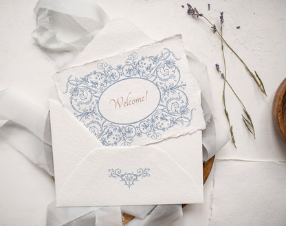 Envelope with ‘Welcome’ label framed by Floral Aesthetics oval border