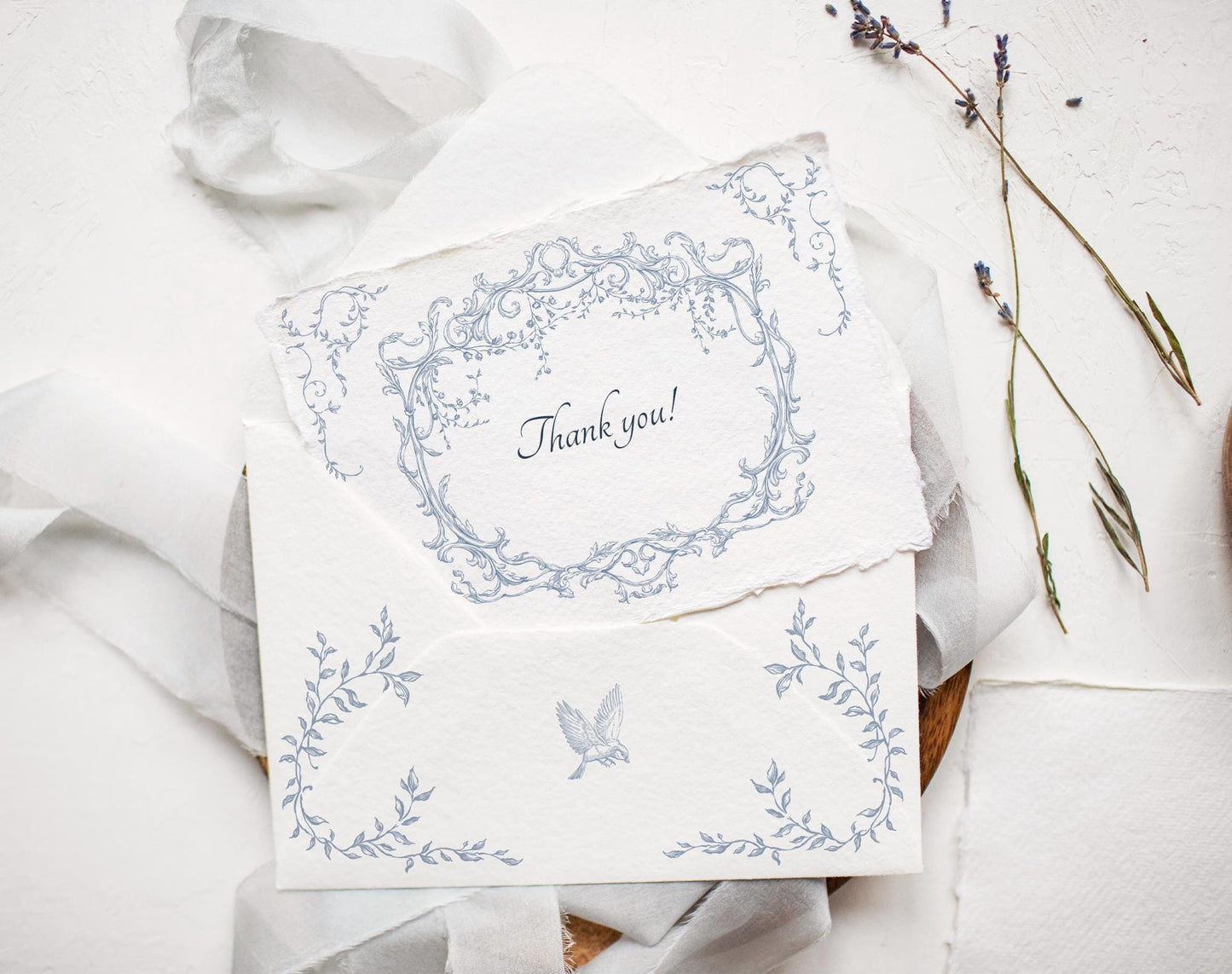 Wedding invitation suite featuring Ornella Blue oval crest and floral border