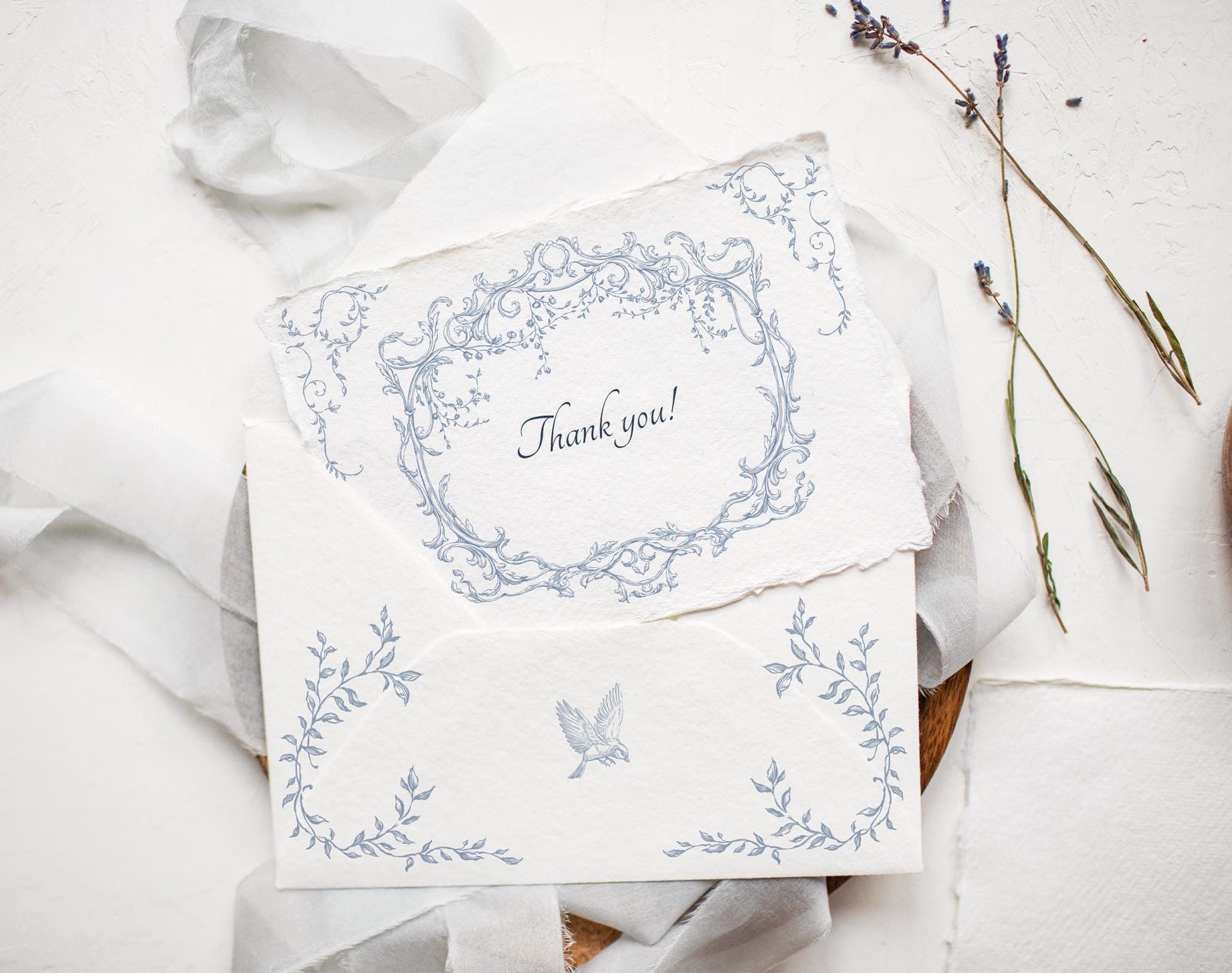 Wedding invitation suite featuring Ornella Blue oval crest and floral border