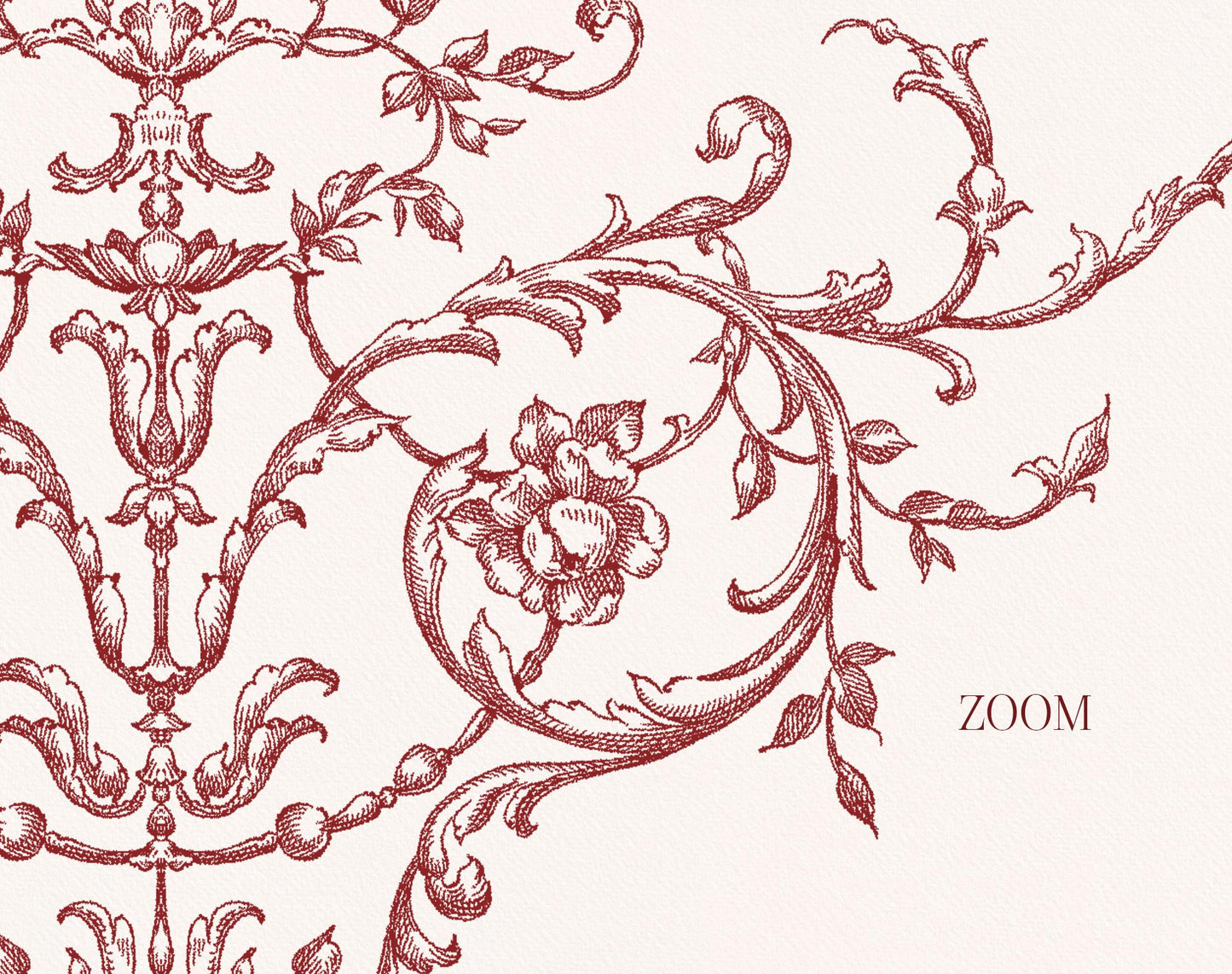 Close-up of burgundy engraved rococo scrollwork with flowers and trailing leaves.