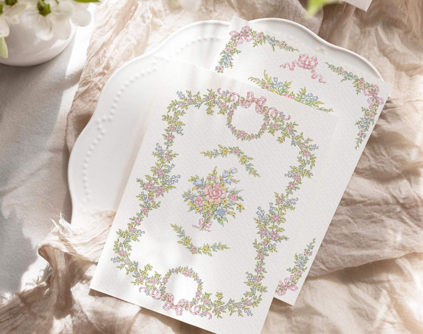 Printed Florena floral frame and bouquet artwork displayed on a white card over a plate and textured fabric.