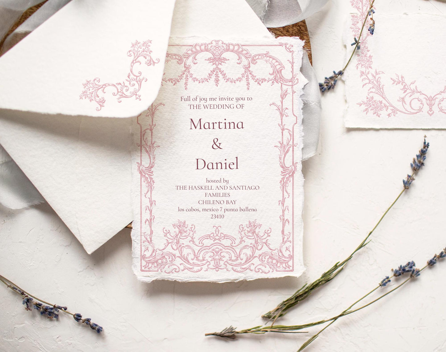 Pink Rococo floral frame shown as a wedding invitation design on textured paper with lavender sprigs.